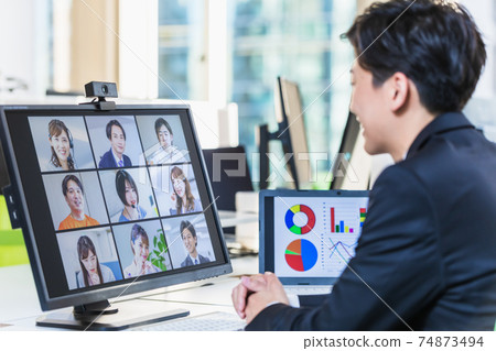 A businessman having an online meeting with his teleworking colleagues 74873494