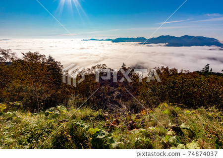 The mysterious scenery of the sea of clouds and the blue sky and sun seen at the entrance to Mt. Aka in the Daisetsu Mountains, Hokkaido 74874037