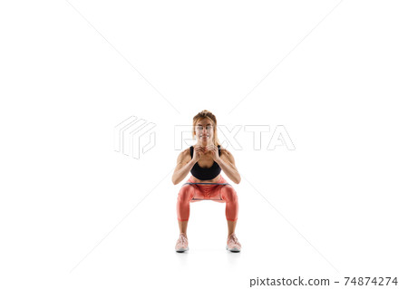 Young caucasian female model in action, motion isolated on white background. Concept of sport, movement, energy and dynamic, healthy lifestyle. Training, practicing. 74874274