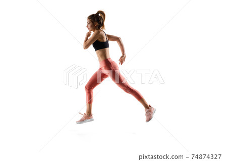Young caucasian female model in action, motion isolated on white background. Concept of sport, movement, energy and dynamic, healthy lifestyle. Training, practicing. 74874327