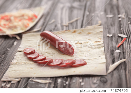 preparation of Shawarma.spicy sausages, pita bread and cabbage salad on a wooden table preparation of Shawarma.spicy sausages, pita bread and cabbage salad on a wooden table 74874795