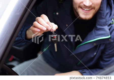 handsome young man showing the key of new car 74874853