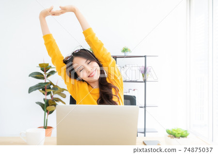 Young asian woman feeling pain in neck and shoulder after working on computer laptop 74875037