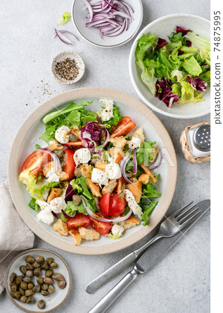 Healthy vegetable salad with croutons, mozzarella cheese and tomatoes Healthy vegetable salad with croutons, mozzarella cheese and tomatoes 74875995