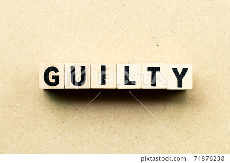 Alphabet letter block in word guilty on wood background Alphabet letter block in word guilty on wood background 74876238