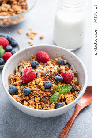 Delicious granola with berries in bowl 74876419