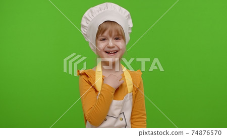 Child girl dressed cook chef baker in apron and hat laughing out loud after hearing funny joke 74876570