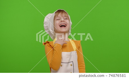 Charming child girl dressed like chef cook laughing out loud after hearing ridiculous anecdote 74876581