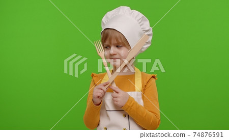 Child girl kid dressed as cook chef with fork and spatula, showing symbol of rejection, disagreement 74876591