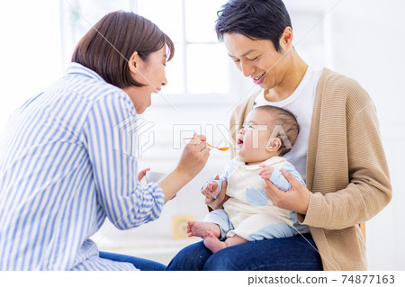 Baby trying to eat baby food Baby trying to eat baby food 74877163