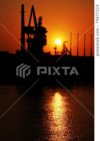 Sunset over imported ships and factories Sunset over imported ships and factories 74877314