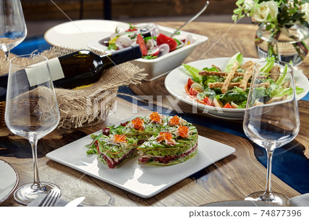 Salad of avokado, seafood, meat, vegetables and pumpkin seeds. Dietary, wholesome and tasty. Banquet festive dishes. Gourmet restaurant menu. White background. 74877396