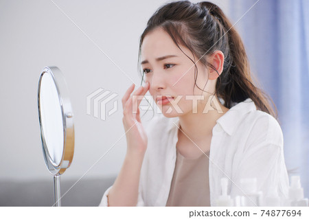 Young woman suffering from skin problems 74877694