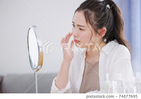 Young woman suffering from skin problems 74877695