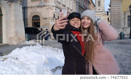 Two young smiling women tourists bloggers taking selfie photos portrait, video conferencing call Two young smiling women tourists bloggers taking selfie photos portrait, video conferencing call 74877932