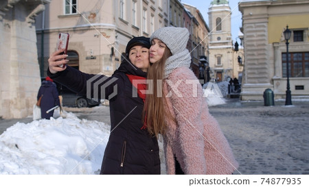 Sisters couple bloggers taking selfie, making video conferencing call on mobile phone on city street 74877935
