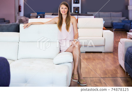 Portrait of woman consumer choosing sofa in furniture shop 74878125