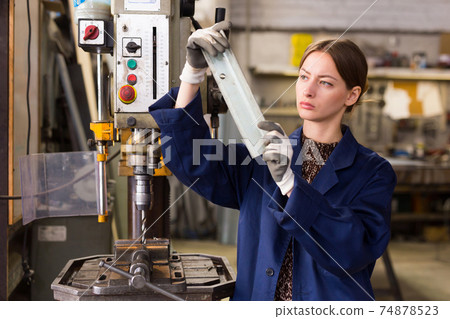 Woman drilling steel structures on drill press Woman drilling steel structures on drill press 74878523
