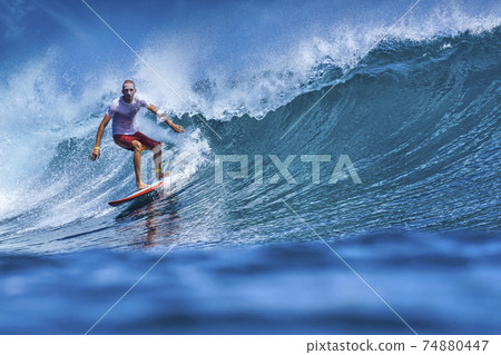 Male surfer on a blue wave Male surfer on a blue wave 74880447