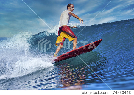 Male surfer on a blue wave Male surfer on a blue wave 74880448