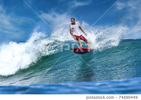 Male surfer on a blue wave 74880449
