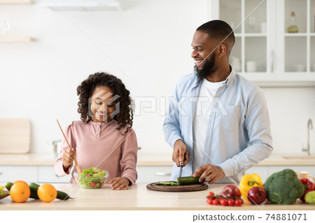 African american father and daughter cooking salad African american father and daughter cooking salad 74881071