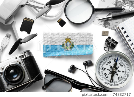 Flag of San Marino and travel accessories on a white background. Flag of San Marino and travel accessories on a white background. 74882717
