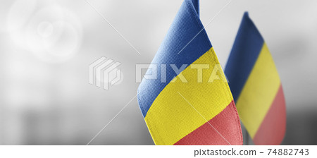 Small national flags of the Romania on a light blurry background Small national flags of the Romania on a light blurry background 74882743