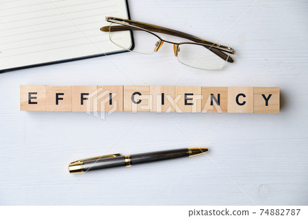 Modern business buzzword - efficiency. Top view on wooden table with blocks. Top view. Modern business buzzword - efficiency. Top view on wooden table with blocks. Top view. 74882787