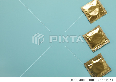 Blank condoms on light blue background, space for text 74884064