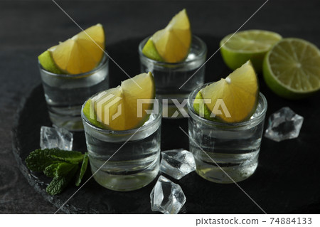 Tray with shots of vodka, lime, mint and ice Tray with shots of vodka, lime, mint and ice 74884133