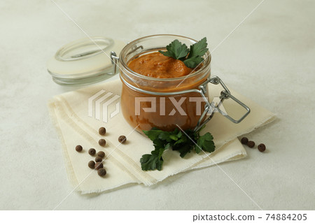 Jar with zucchini caviar on white textured table Jar with zucchini caviar on white textured table 74884205