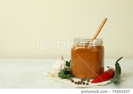 Jar with zucchini caviar on white textured table Jar with zucchini caviar on white textured table 74884207