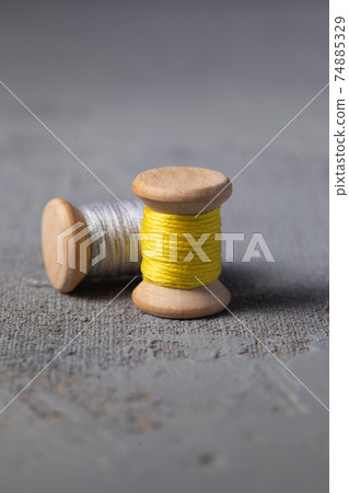 Illuminating Yellow and Ultimate grey colored threads wooden bobbins Illuminating Yellow and Ultimate grey colored threads wooden bobbins 74885329