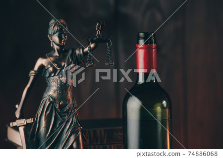 Bottle of wine and lady of justice as a symbol of law close-up 74886068