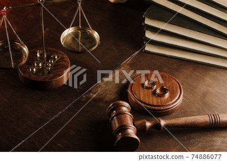 Divorce concept. Wooden gavel and rings in notary public office Divorce concept. Wooden gavel and rings in notary public office 74886077