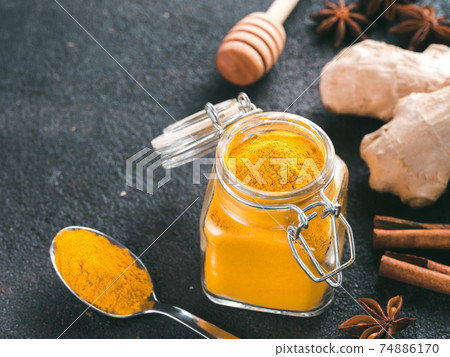 turmeric powder in glass jar and spoon 74886170