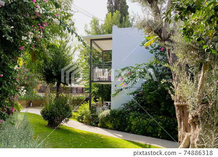 The territory of the hotel in the resort town with an incredibly beautiful garden, beautiful flowering shrubs and fruit trees.  The building on the territory of the hotel, the concept of recreation 74886318