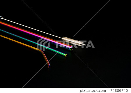 The modern trend caring for the environment. Self kit of reusable metal beverage straws of various diameters, colors and shapes with cleaning tool. On black background The modern trend caring for the environment. Self kit of reusable metal beverage straws of various diameters, colors and shapes with cleaning tool. On black background 74886740