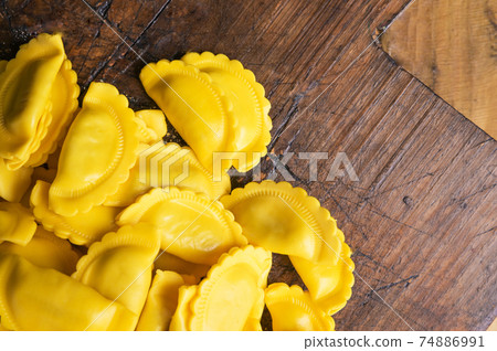 Small ravioli with cheese or meat to cook in broth, a traditional dish for celebrations in italy Small ravioli with cheese or meat to cook in broth, a traditional dish for celebrations in italy 74886991