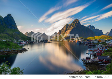 Mount Olstind and Reine fishing village on Lofoten islands at sunset Mount Olstind and Reine fishing village on Lofoten islands at sunset 74887098