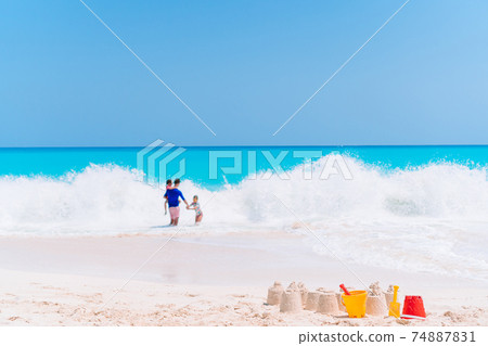Sandcastle at white tropical beach with plastic kids toys Sandcastle at white tropical beach with plastic kids toys 74887831