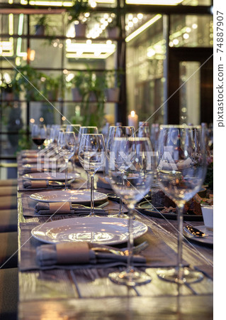 Modern veranda restaurant interior, banquet setting, glasses, plates Modern veranda restaurant interior, banquet setting, glasses, plates 74887907