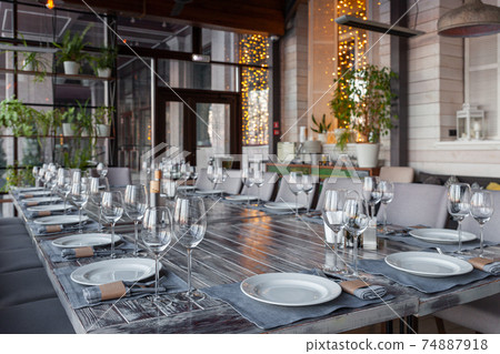 Modern veranda restaurant interior, banquet setting, glasses, plates Modern veranda restaurant interior, banquet setting, glasses, plates 74887918
