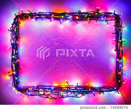 Christmas lights frame on snow background, purple color Christmas lights frame on snow background, purple color 74889070