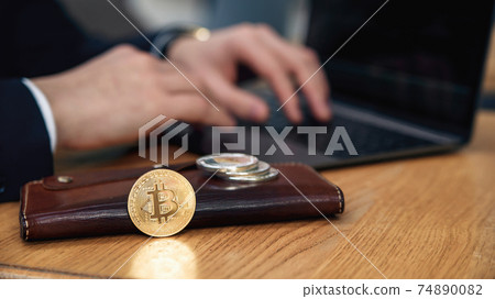 Businessman works on a laptop in his workplace. Cryptocurrency business concept. Electronic virtual money investment. Bitcoin, Litecoin, Ethereum coins on wallet. Exchange bitcoin cash for a dollar. Businessman works on a laptop in his workplace. Cryptocurrency business concept. Electronic virtual money investment. Bitcoin, Litecoin, Ethereum coins on wallet. Exchange bitcoin cash for a dollar. 74890082