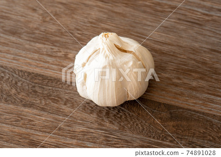 Garlic placed on a dark brown wood table Garlic placed on a dark brown wood table 74891028