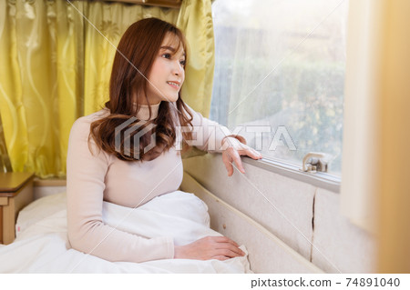 happy woman looking view at window of a camper RV van motorhome 74891040