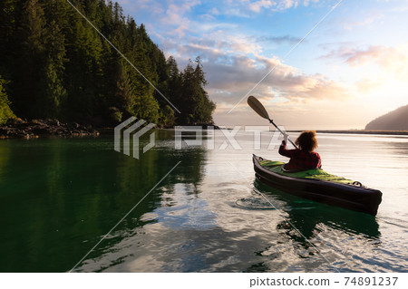 Adventurous Girl kayaking in the Pacific Ocean. Adventurous Girl kayaking in the Pacific Ocean. 74891237