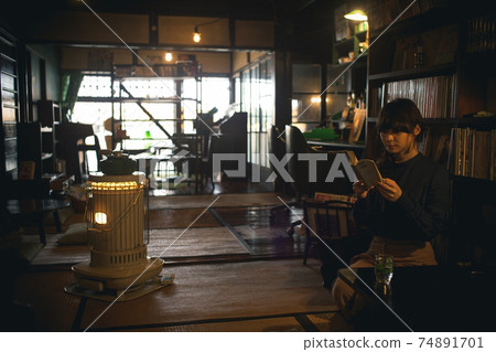 A room with a stove and a woman reading a book Old folk house A room with a stove and a woman reading a book Old folk house 74891701